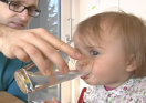 Kleinkind trinkt aus Wasserglas