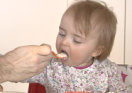 Kleinkind wird mit Löffel gefüttert