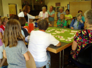 Spiel mit rund 20 Teilnehmern am Tag der Generationen - gemischte Teams aus Kindern und Seniorinnen sitzen zusammen und lösen Aufgaben