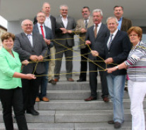 Bürgermeister stehen auf Treppe und halten Fadengeflecht als Symbol ihre Kooperation