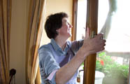 Frau putzt ein großes Fenster