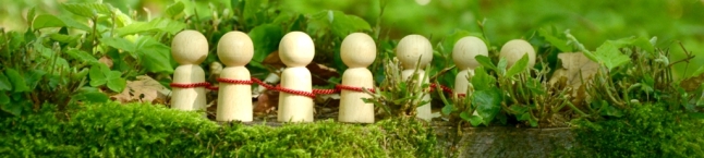 Spielfiguren mit rotem Faden verbunden im Wald