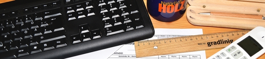 Schreibtisch mit Tastatur, Telefon, Stift und Tasse