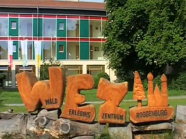 Drei große Holzbuchstaben "WEZ" vor dem Gebäude des Walderlebniszentrum Roggenburg.