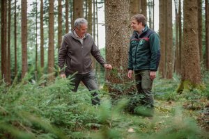 Waldbesitzer im Beratungsgespräch mit einem Forstbeamten im Wald