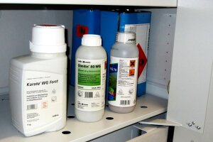 verschiedene Flaschen mit Pflanzenschutzmittel in einem Schrank